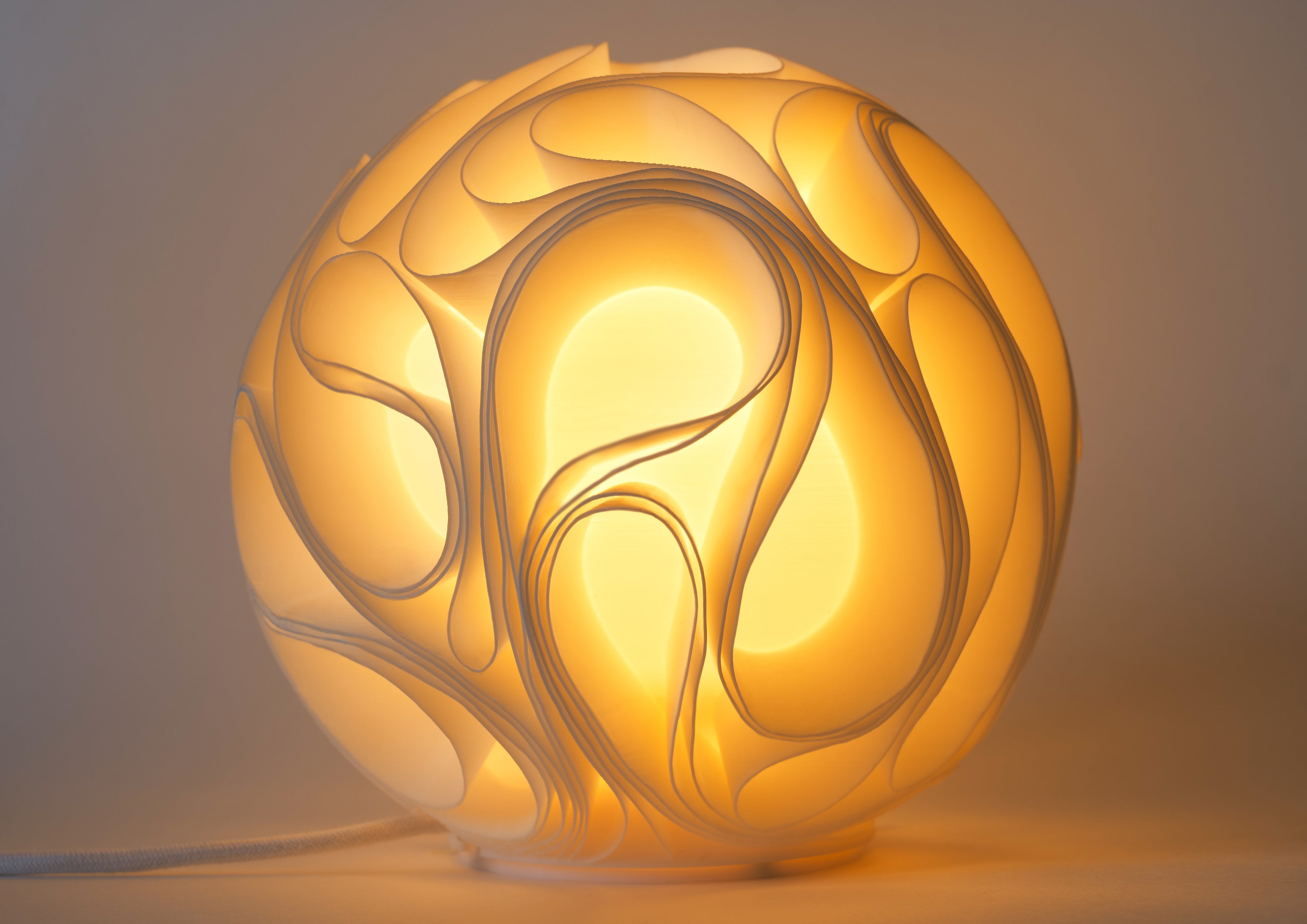 Organische sfeerlamp met warm licht en vloeiende sculpturale lijnen
