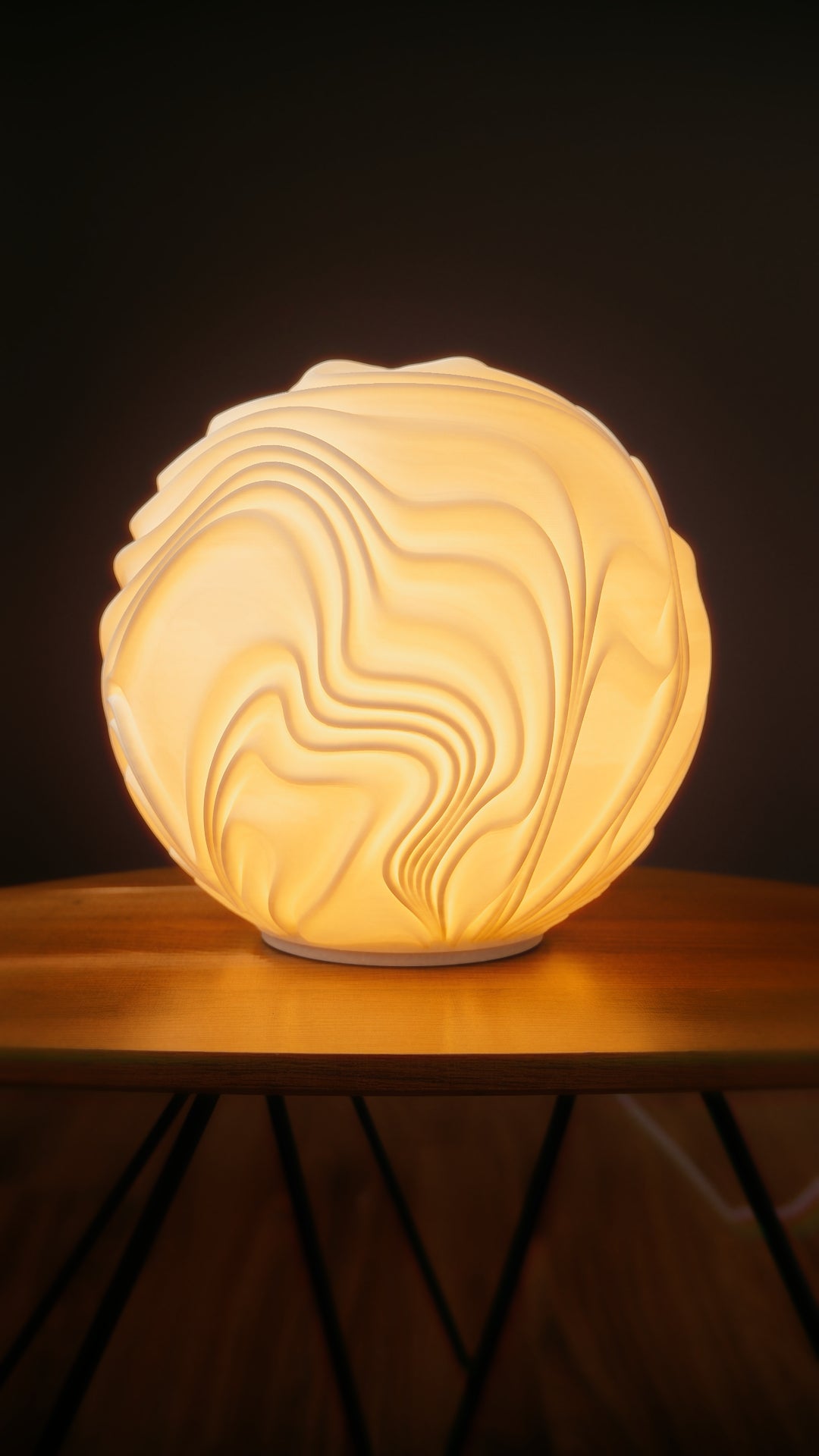 Flow Sculpted designlamp met warme gloed op tafel in sfeervol interieur