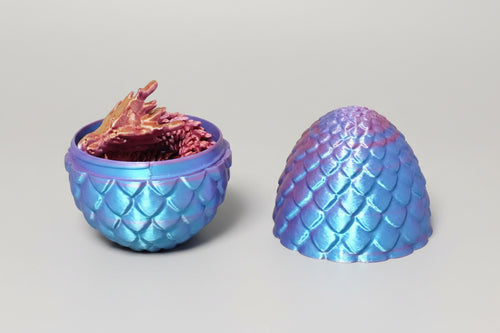 Open multicolor drakenei met schubstructuur en los verkrijgbaar 3D-geprint draakje als sfeerbeeld.