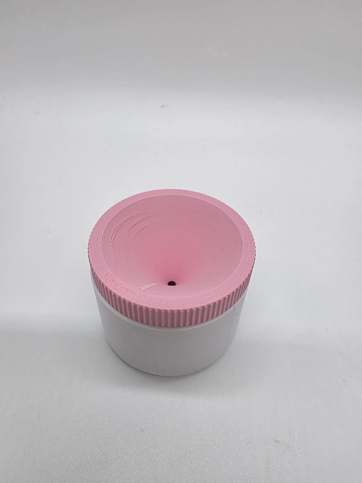 Roze 3D-geprinte fruitvliegvanger met trechtervormige bovenzijde en wit bakje.