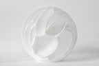 Lava Sculpted sfeerlamp met warme verlichting op een houten dressoir in een modern interieur.