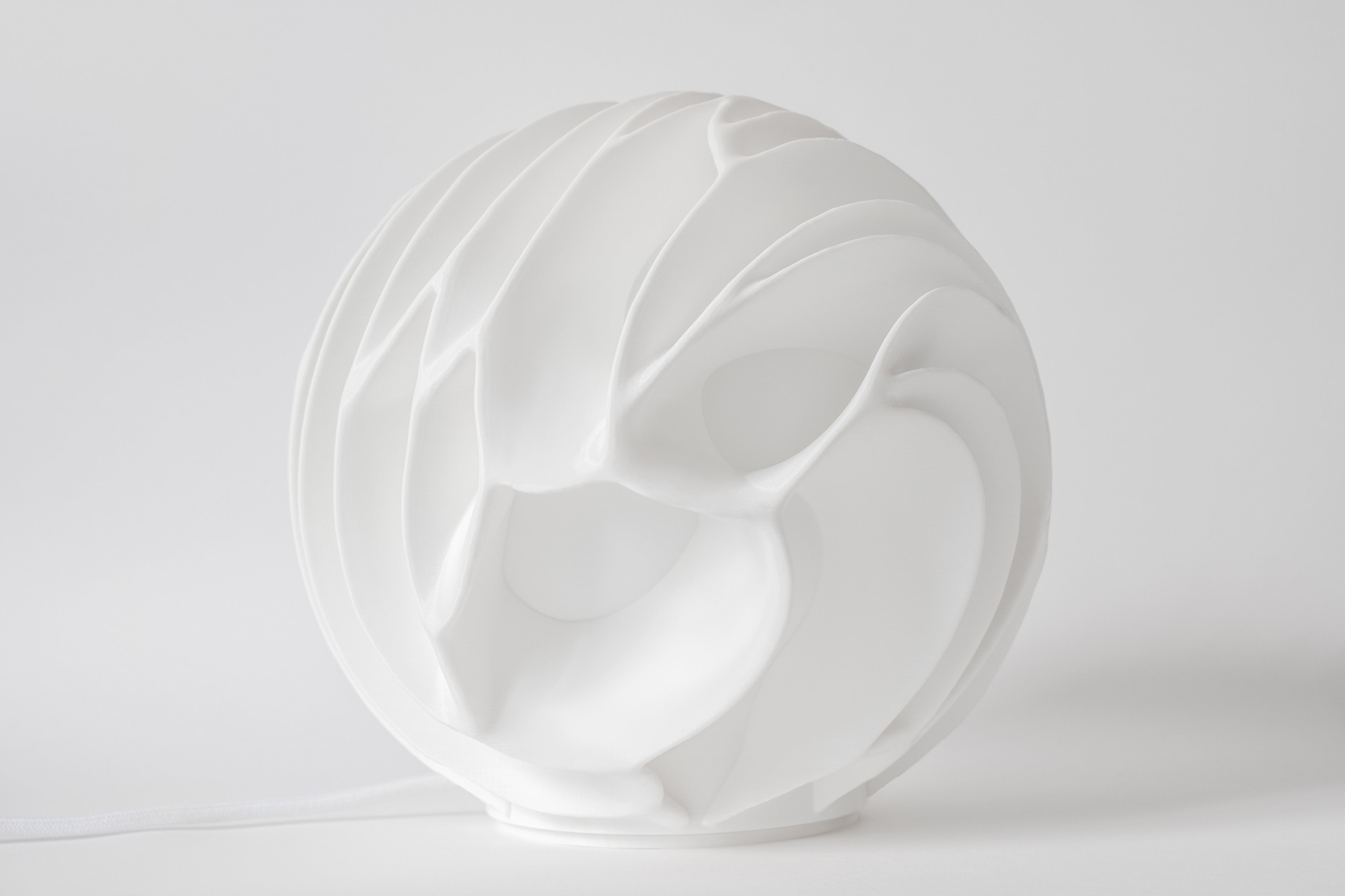 Lava Sculpted sfeerlamp met warme verlichting op een houten dressoir in een modern interieur.