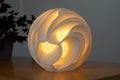 Witte Lava Sculpted designlamp met ronde vorm en gelaagde organische openingen.