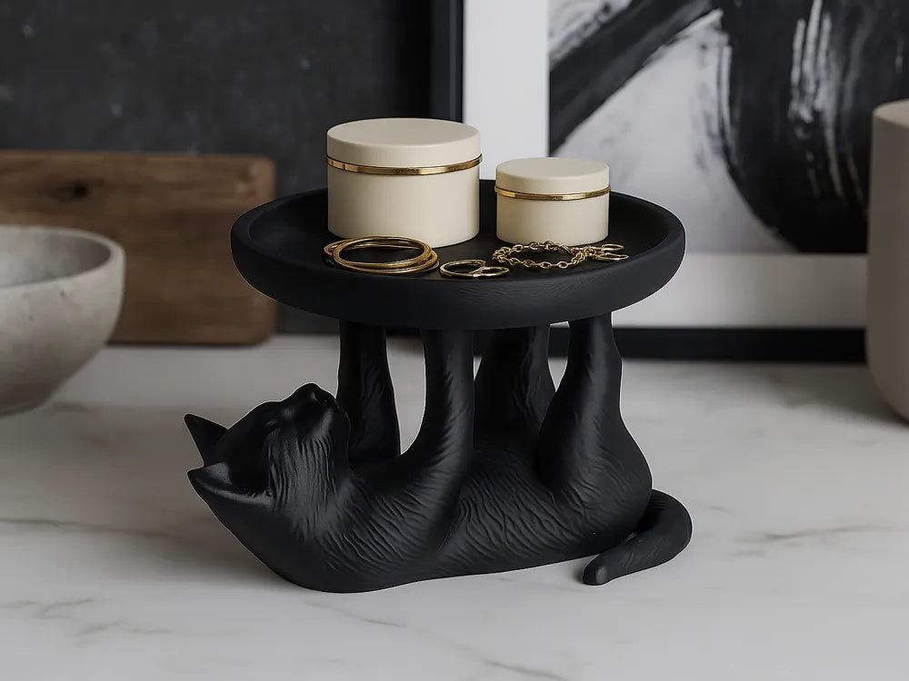 Zwart kat sieradenschaaltje met sieraden op een kaptafel