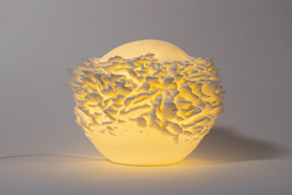 Atoll compacte sfeerlamp met gelaagde koraalstructuur op lichte achtergrond.
