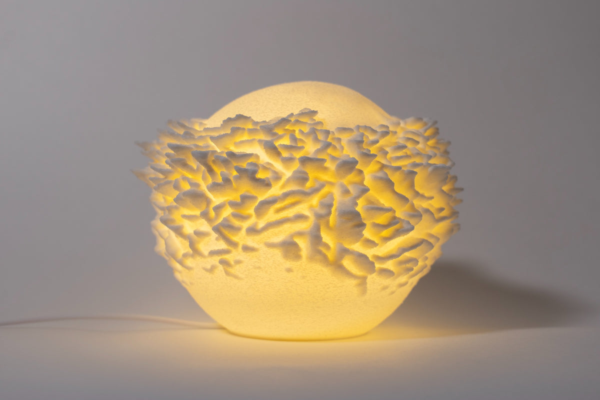 Atoll compacte sfeerlamp met gelaagde koraalstructuur op lichte achtergrond.