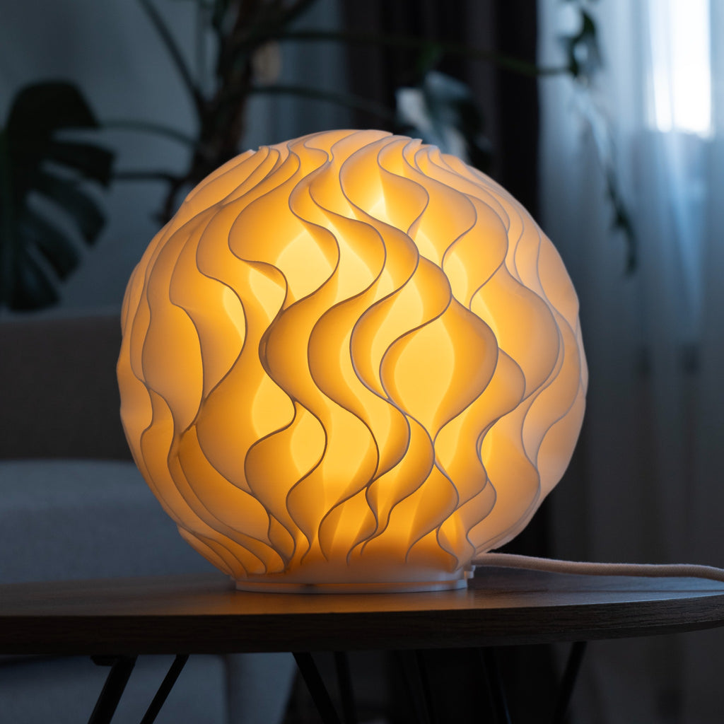 Bloom design tafellamp brandend op een tafel in een sfeervol interieur.