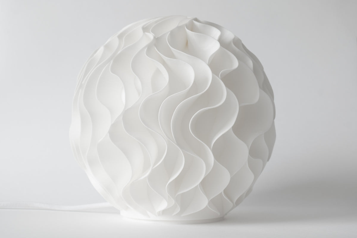 Witte Bloom design tafellamp uitgeschakeld met gelaagde organische vormen.