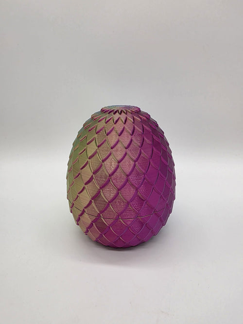 3D-geprint multicolor drakenei met schubstructuur in roze, goud en groene tinten.