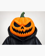 Close-up van het oranje pompoenhoofd met zwarte ogen en mond van de Halloween Pumpkin Reaper.