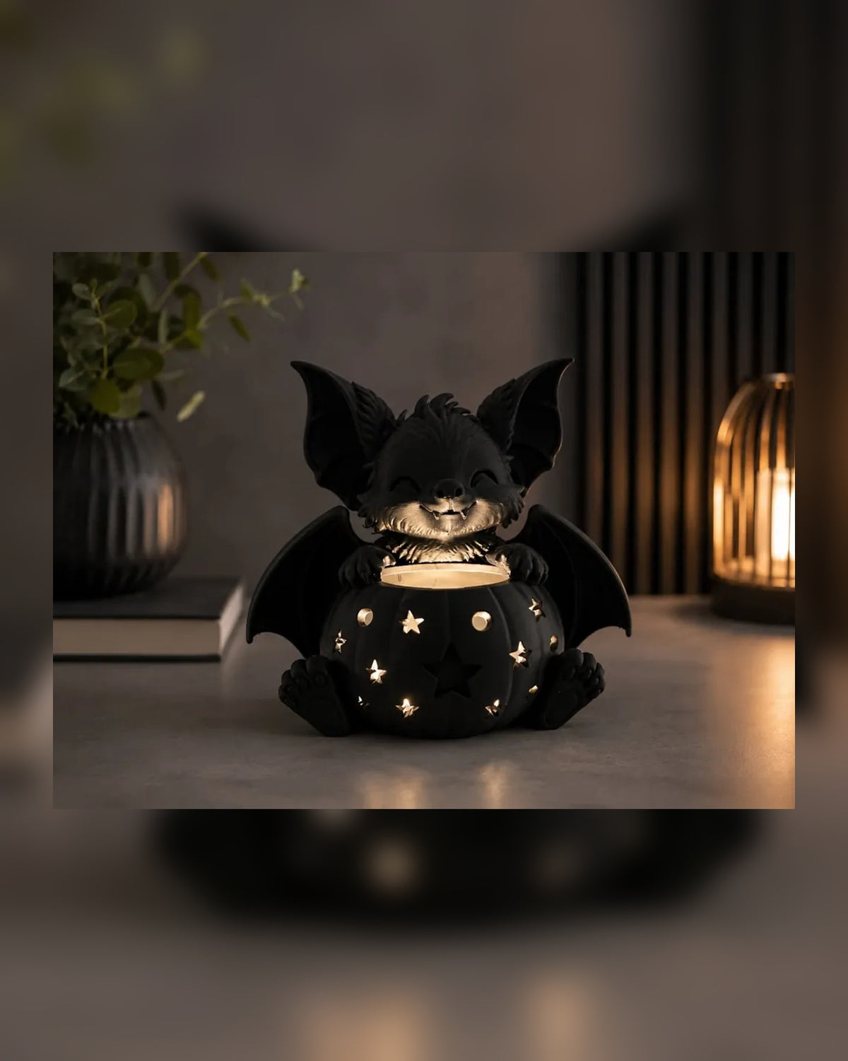 Verlichte zwarte Halloween vleermuislantaarn met warm LED-licht in een sfeervol interieur.