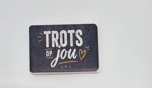 Keramische koelkastmagneet met de tekst Trots op jou in wit en goud op een donkere achtergrond.