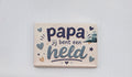 Keramische koelkastmagneet met de tekst Papa jij bent een held, hartjes en sterren op een lichte achtergrond.