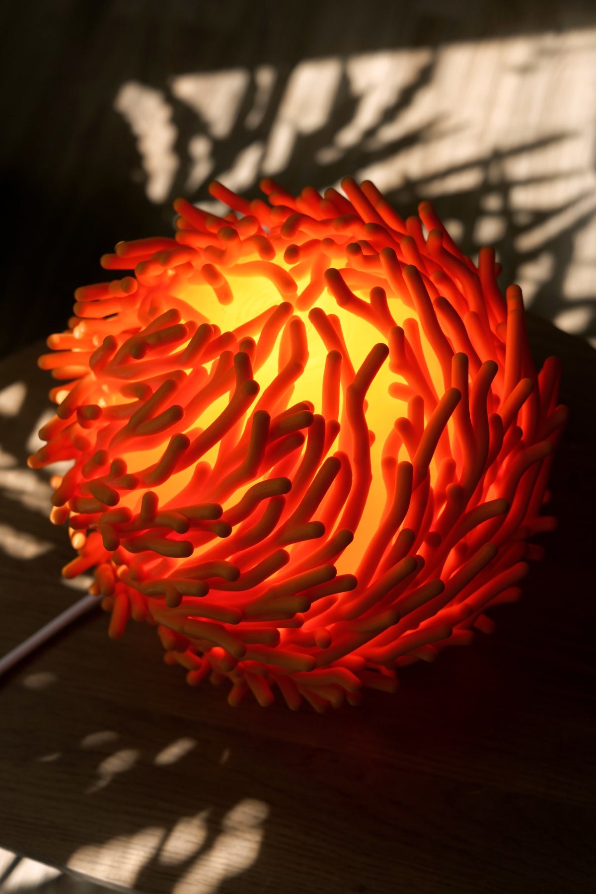 Rode Koraal organische design tafellamp met warm licht en bijzonder schaduwspel.