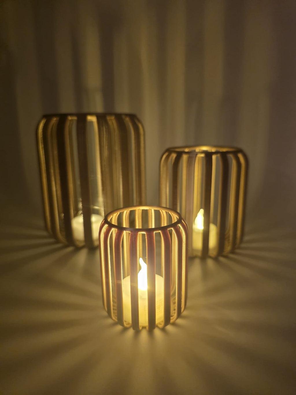 Set van drie LED-theelichthouders met ribstructuur en warm sfeervol licht.