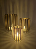 Set van drie LED-theelichthouders met ribstructuur en warm sfeervol licht.