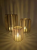 Set van drie LED-theelichthouders met ribstructuur en warm sfeervol licht.