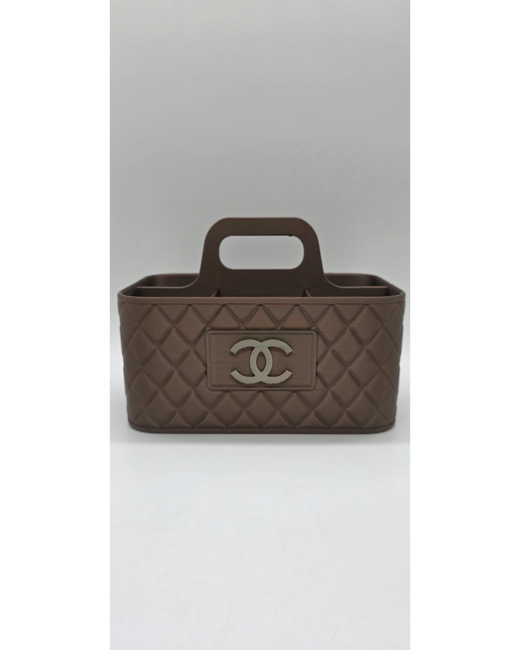 Bruine make-up organiser met handgreep en quilted patroon op lichte achtergrond.