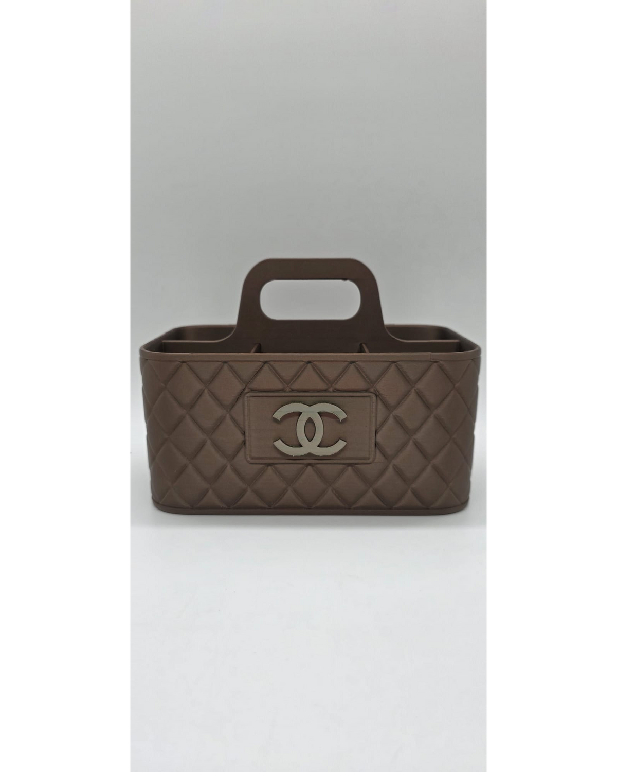 Bruine make-up organiser met handgreep en quilted patroon op lichte achtergrond.