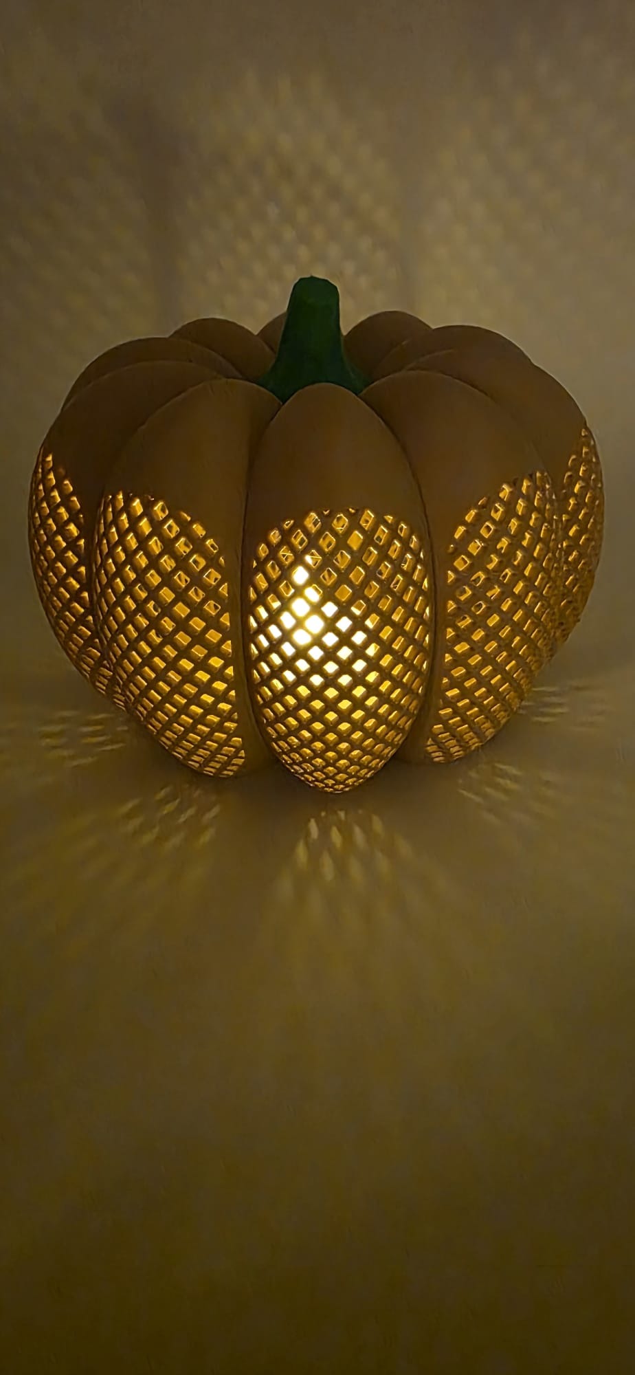 Latte pompoen decoratie met verlicht rasterpatroon.