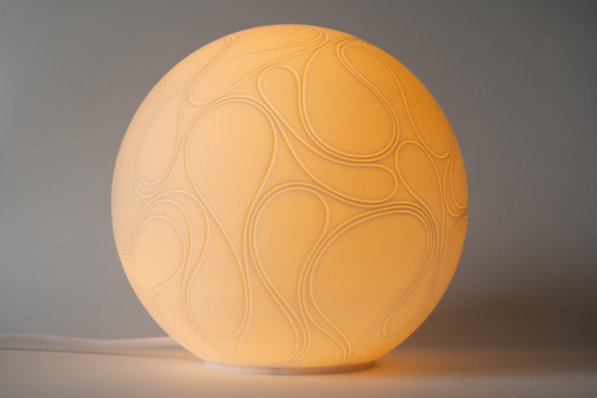 River design tafellamp met vloeiend reliëf en warm sfeervol licht.