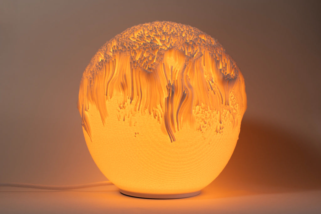 Tide sculpturale sfeerlamp met organisch reliëf en warm sfeervol licht.