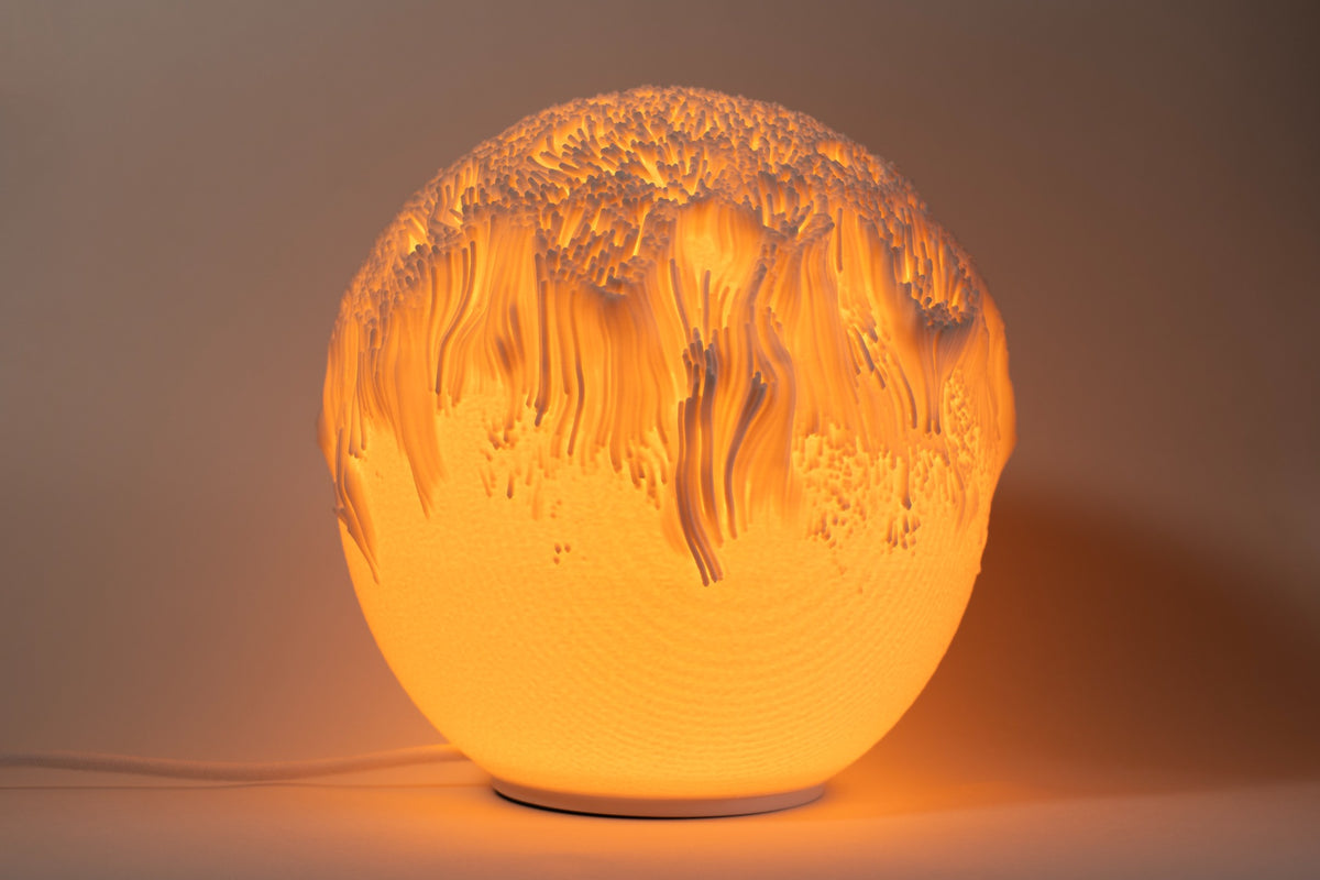 Tide sculpturale sfeerlamp met organisch reliëf en warm sfeervol licht.